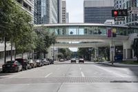 an image of cars at the corner of a city street with a pedestrian walkway in the foreground