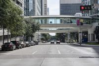 an image of cars at the corner of a city street with a pedestrian walkway in the foreground