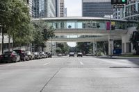 an image of cars at the corner of a city street with a pedestrian walkway in the foreground