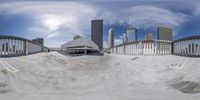 the sky above the city is full of skyscrapers and snow covered ground with several tracks