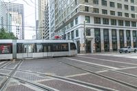 a city tram moves along a sidewalk as cars pass by in the city streets below