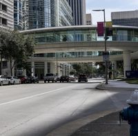 the intersection of an urban city with cars on it's roadway and traffic lights