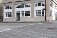 an image of a corner with traffic lights and a crosswalk in front of the building