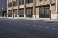 a person in the middle of an empty road with no people on it, walking down a sidewalk