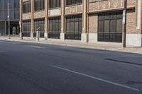 a person in the middle of an empty road with no people on it, walking down a sidewalk