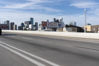 an empty highway with some signs on it in the city area in front of a few buildings