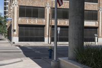 this is an empty street with buildings in the background and a flag pole that says fire department