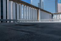 a person skate boarding on a bridge and surrounded by tall buildings and other high rise office towers