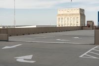 a parking lot with a stop sign in the distance near a building with tall windows