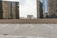 the empty parking lot is full of cars and buildings with reflections on it's windows