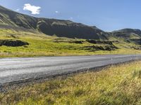 a view of some hills and road in iceland, near a sign on the side