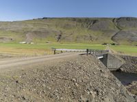 a large dirt road next to a hill with a long train coming out of it