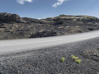 a person riding on the road on a motorcycle in the middle of a barren landscape