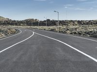 a deserted road in the middle of the desert at dusk with two lane markings on both sides