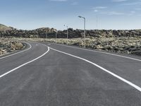 a deserted road in the middle of the desert at dusk with two lane markings on both sides