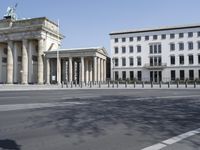 a large stone building has columns on the corner with a gate on each side of it