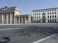 a large stone building has columns on the corner with a gate on each side of it