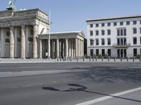 a large stone building has columns on the corner with a gate on each side of it