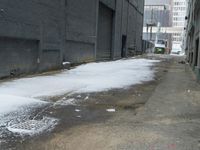 a fire hydrant in the middle of an icy alleyway leading to tall buildings