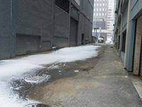 a fire hydrant in the middle of an icy alleyway leading to tall buildings