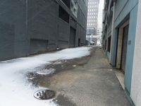 a fire hydrant in the middle of an icy alleyway leading to tall buildings