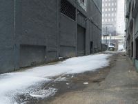 a fire hydrant in the middle of an icy alleyway leading to tall buildings