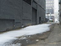 a fire hydrant in the middle of an icy alleyway leading to tall buildings