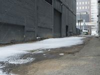 a fire hydrant in the middle of an icy alleyway leading to tall buildings