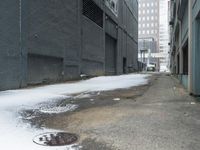 a fire hydrant in the middle of an icy alleyway leading to tall buildings