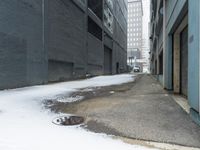 a fire hydrant in the middle of an icy alleyway leading to tall buildings