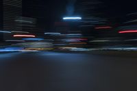 cars speeding down the road in a blurry picture at night time with lights streaking on them