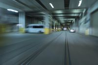 cars driving through an underground tunnel at night time, blurred with lights as the speed of light is approaching