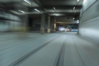 cars driving through an underground tunnel at night time, blurred with lights as the speed of light is approaching