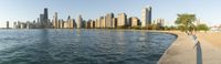 a man stands by the side of the water near some water and buildings in a city