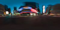 cars are driving in the city at night time with blurred images and buildings in the background