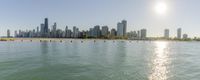 a view of a city skyline over a lake from the beach and pier with several boats