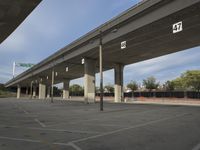 an empty parking lot under a bridge is shown in this photo taken in the us