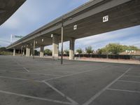 an empty parking lot under a bridge is shown in this photo taken in the us