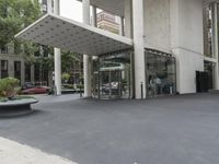 an empty street next to a parking lot with buildings and parked cars on the side of it