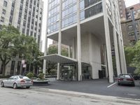 an empty street next to a parking lot with buildings and parked cars on the side of it