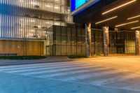 the entrance to a building has illuminated columns and lights on both sides of the building