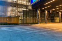 the entrance to a building has illuminated columns and lights on both sides of the building