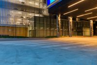 the entrance to a building has illuminated columns and lights on both sides of the building