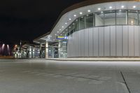 a parking garage filled with lots of glass walls and silver trims on top of it