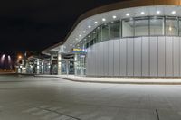 a parking garage filled with lots of glass walls and silver trims on top of it