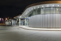 a parking garage filled with lots of glass walls and silver trims on top of it