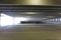 a empty parking garage is in the middle of a tunnel for vehicles to pass by