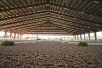 the inside of an arena with stalls and seats on both sides of it and the floor is covered in dirt