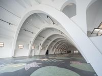 an indoor art installation with arches and floor tiles in an office building, which is equipped with carpeted floors