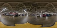 the indoor parking garage is filled with cars and vans, including many parked at one time